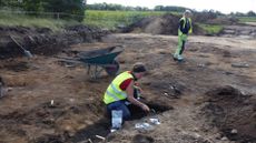 Two archaeologists excavate a burial site