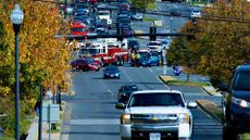 photo of a fire truck, ambulance and police vehicles blocking off traffic at an intersection where a crash appears to have taken place