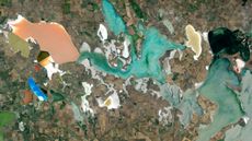 A satellite photo of roughly a dozen brightly colored lagoons