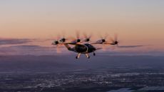 An aerial picture of the six-rotor Joby Aviation hydrogen-electric air taxi flying over California at sunset.