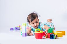 A baby plays with colorful toys.